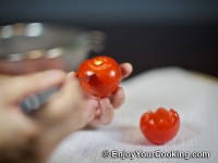 Cut top part of tomato with sharp knife, then cut once more at about 60 degrees