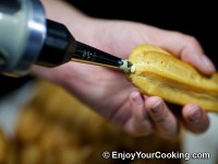 Fill eclair with custard from a side